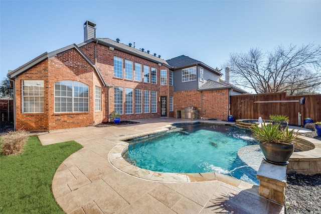 view of pool with an in ground hot tub, a patio area, fence, and a fenced in pool