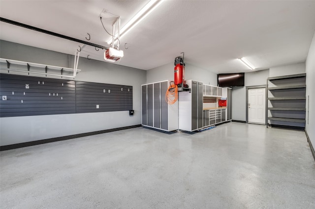 garage with a garage door opener and baseboards