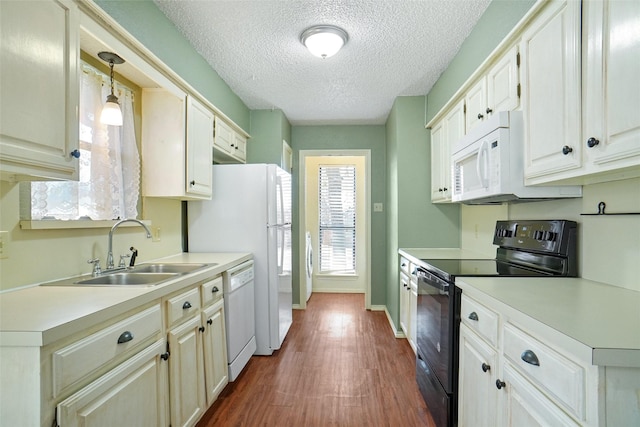 kitchen featuring dark wood-style floors, light countertops, white appliances, and a sink