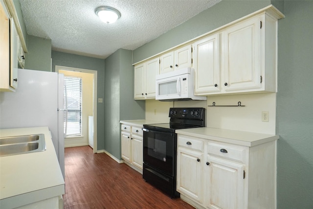 kitchen featuring electric range, dark wood finished floors, white microwave, light countertops, and a textured ceiling