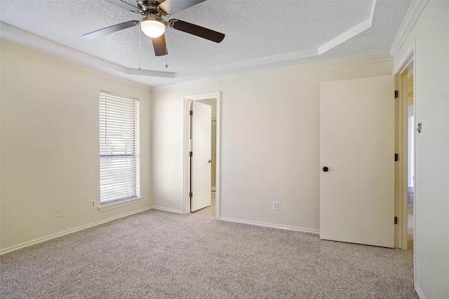 empty room featuring ornamental molding, carpet, a textured ceiling, and baseboards