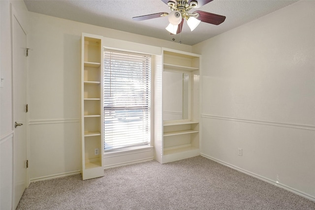 unfurnished bedroom with a textured ceiling, multiple windows, and carpet