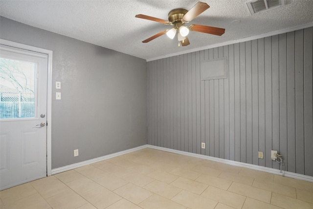 empty room featuring a textured ceiling, baseboards, visible vents, and a ceiling fan