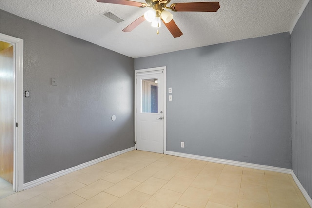 unfurnished room with ceiling fan, a textured ceiling, visible vents, and baseboards