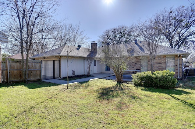 rear view of property featuring a yard, a patio area, fence, and brick siding