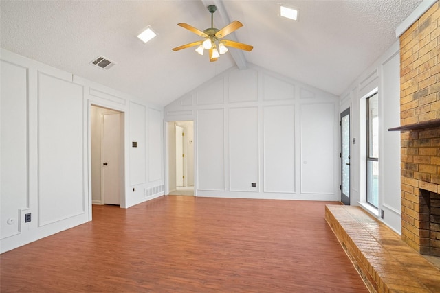 unfurnished living room with a brick fireplace, visible vents, and a decorative wall