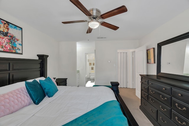 bedroom featuring light carpet, visible vents, ensuite bath, and ceiling fan