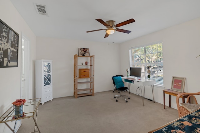 carpeted office space featuring visible vents and ceiling fan