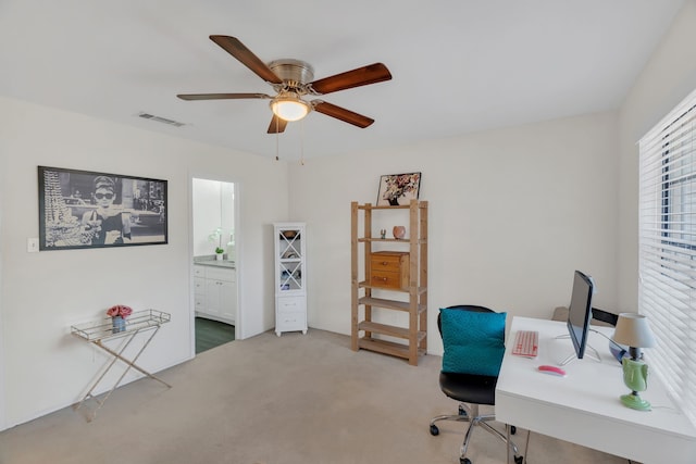 carpeted office space with visible vents and ceiling fan