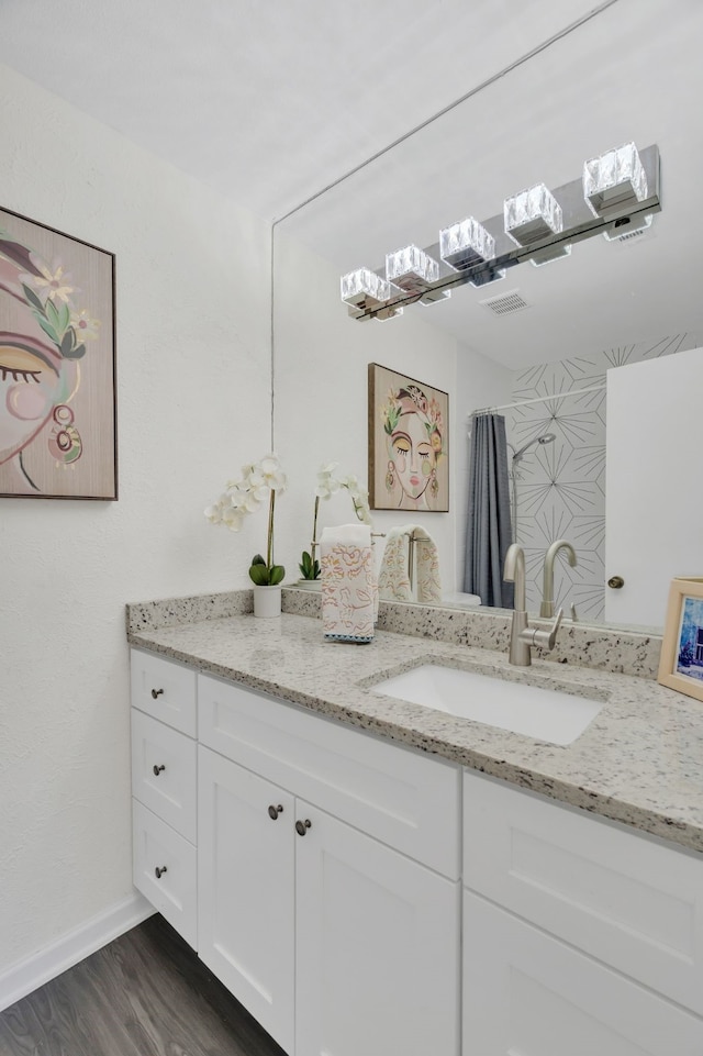 bathroom with baseboards, wood finished floors, and vanity