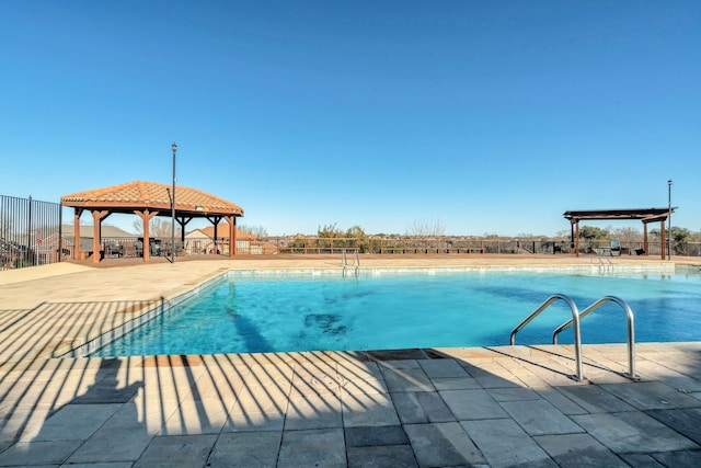 community pool featuring a gazebo, a patio area, and fence