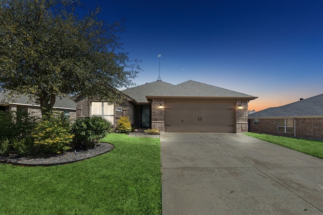 view of front of home with a garage, a front yard, concrete driveway, and brick siding