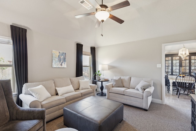 living area with carpet floors, visible vents, baseboards, and ceiling fan with notable chandelier