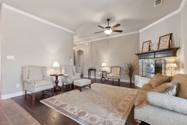 living room with visible vents, arched walkways, wood finished floors, and ornamental molding