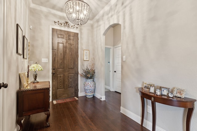 entryway with arched walkways, a chandelier, wood finished floors, and baseboards