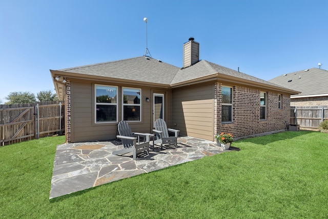 back of house with a yard, a patio, a chimney, a shingled roof, and a fenced backyard