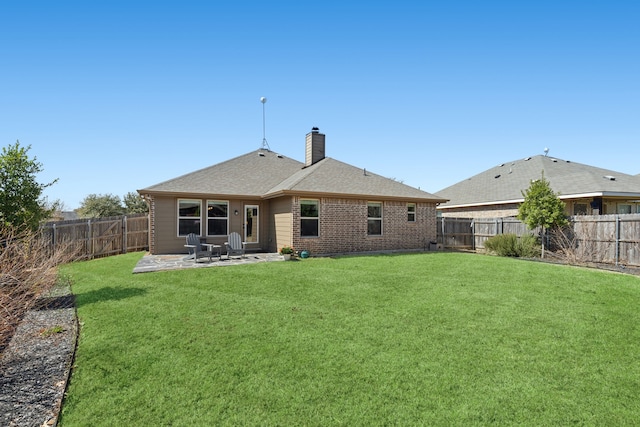 rear view of house featuring a fenced backyard, a patio, a chimney, and a lawn