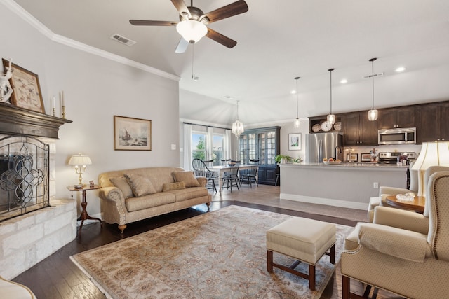 living area featuring dark wood finished floors, visible vents, and crown molding