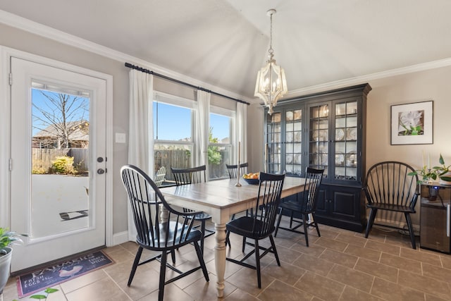 dining area featuring an inviting chandelier, baseboards, and ornamental molding