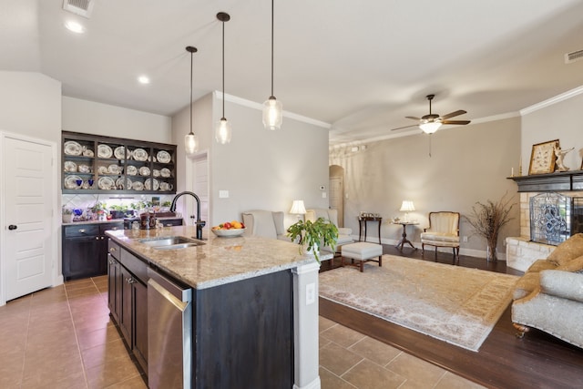 kitchen featuring arched walkways, crown molding, open floor plan, a sink, and dishwasher