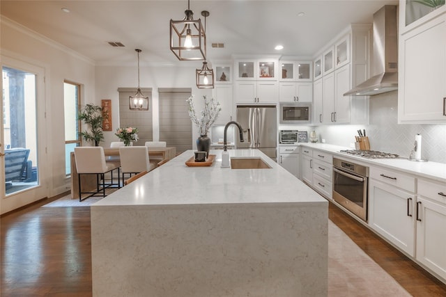 kitchen with visible vents, decorative backsplash, dark wood-style floors, appliances with stainless steel finishes, and wall chimney range hood