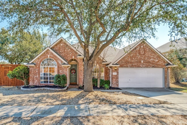 view of front of home featuring a garage, brick siding, fence, and driveway