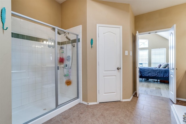 bathroom featuring tile patterned floors, a shower stall, baseboards, and ensuite bathroom