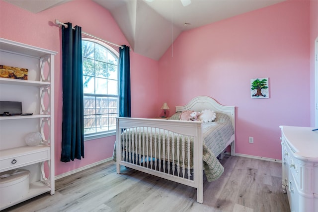 bedroom with light wood finished floors, multiple windows, baseboards, and vaulted ceiling