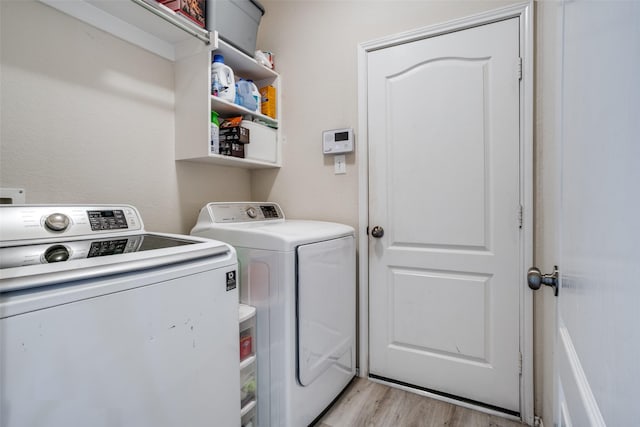 clothes washing area featuring light wood-type flooring, laundry area, and independent washer and dryer