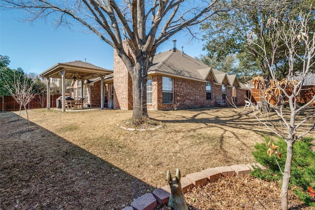 rear view of property featuring a patio, brick siding, and fence