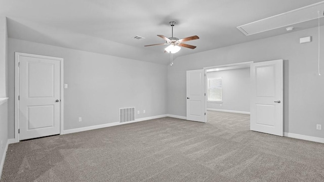 empty room featuring carpet floors, attic access, and visible vents