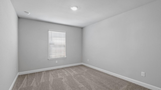 unfurnished room with carpet and baseboards