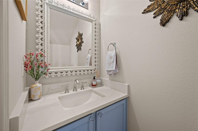 bathroom featuring a textured wall and vanity