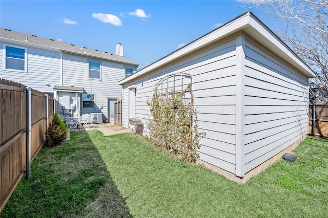 back of property featuring a fenced backyard and a lawn