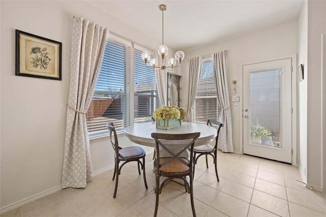 dining space with light tile patterned floors, baseboards, and a chandelier