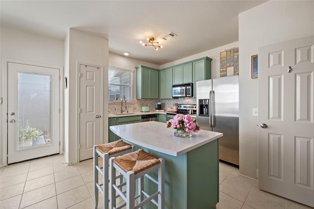 kitchen featuring light tile patterned flooring, a sink, visible vents, appliances with stainless steel finishes, and green cabinetry