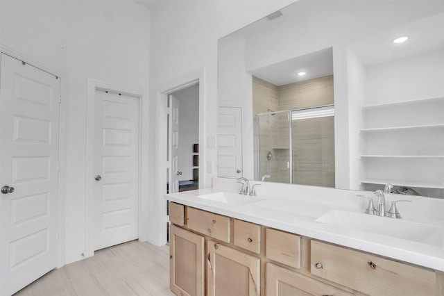 bathroom with double vanity, recessed lighting, a sink, and a shower stall