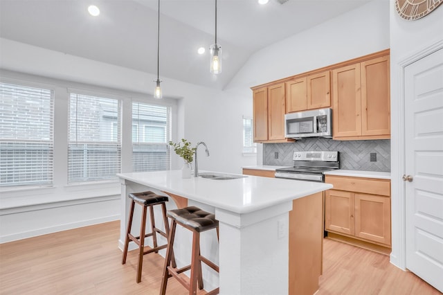 kitchen with light brown cabinetry, appliances with stainless steel finishes, a sink, and light countertops