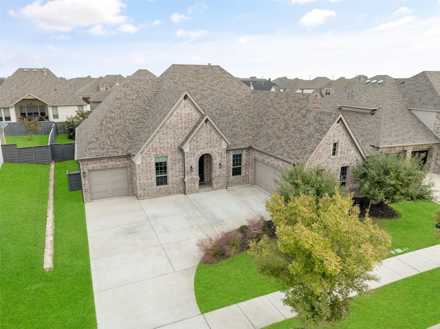 french provincial home with brick siding, roof with shingles, and a front yard