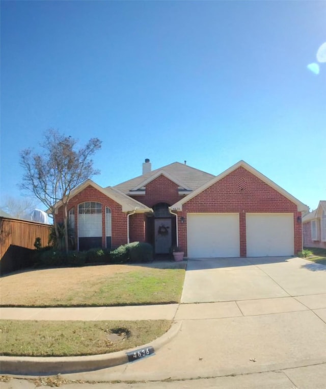 single story home featuring driveway, an attached garage, a chimney, a front lawn, and brick siding