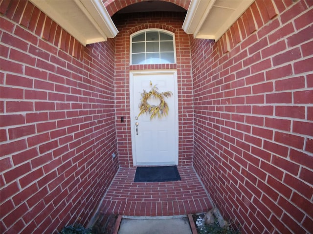 view of exterior entry featuring brick siding