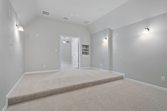 unfurnished room with baseboards, visible vents, and vaulted ceiling