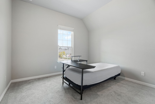 carpeted bedroom featuring vaulted ceiling and baseboards