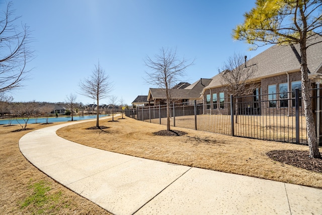 view of home's community featuring fence