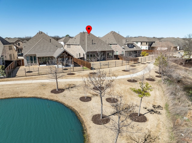 view of home's community featuring a water view, fence private yard, and a residential view