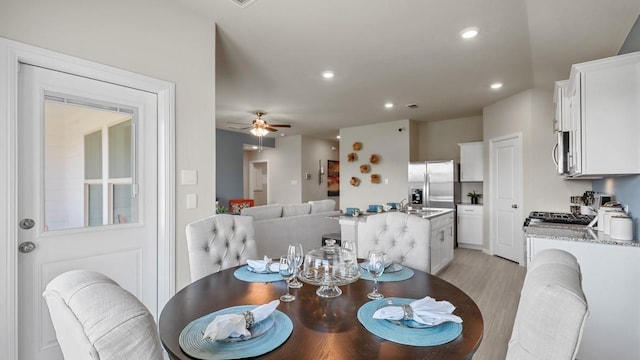 dining space with light wood-type flooring, recessed lighting, and a ceiling fan