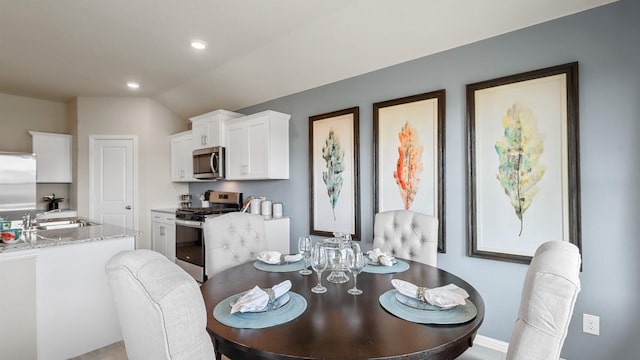 dining space with recessed lighting and vaulted ceiling