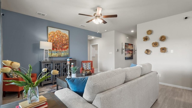 living area with visible vents, ceiling fan, and baseboards