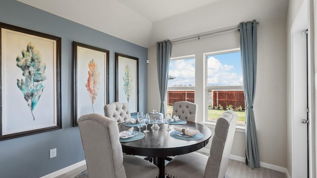 dining space featuring light wood-type flooring and baseboards