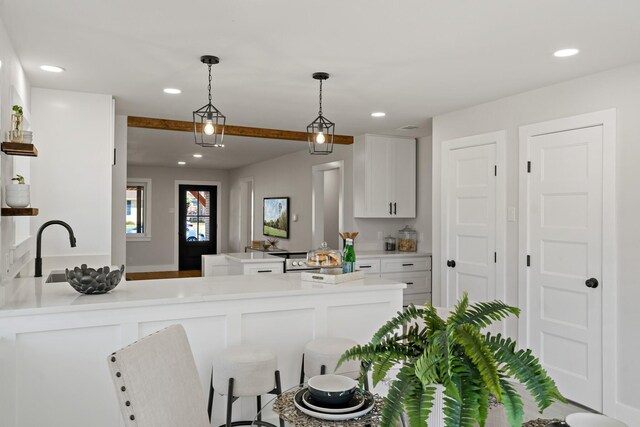 kitchen with a peninsula, white cabinetry, light countertops, and recessed lighting